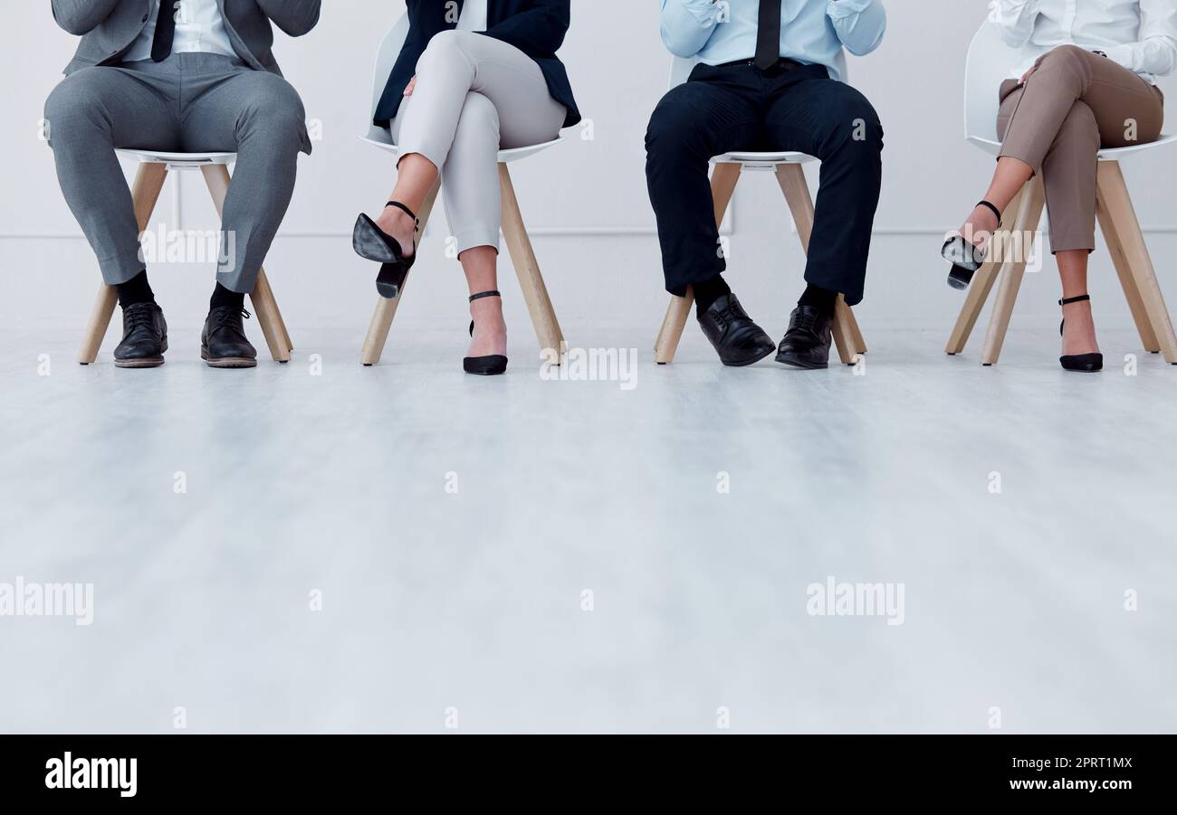 Business people waiting at recruitment company for a job interview or hiring meeting. Closeup of a group of employees sitting on chairs in a waiting room or office to join a corporate team project. Stock Photo