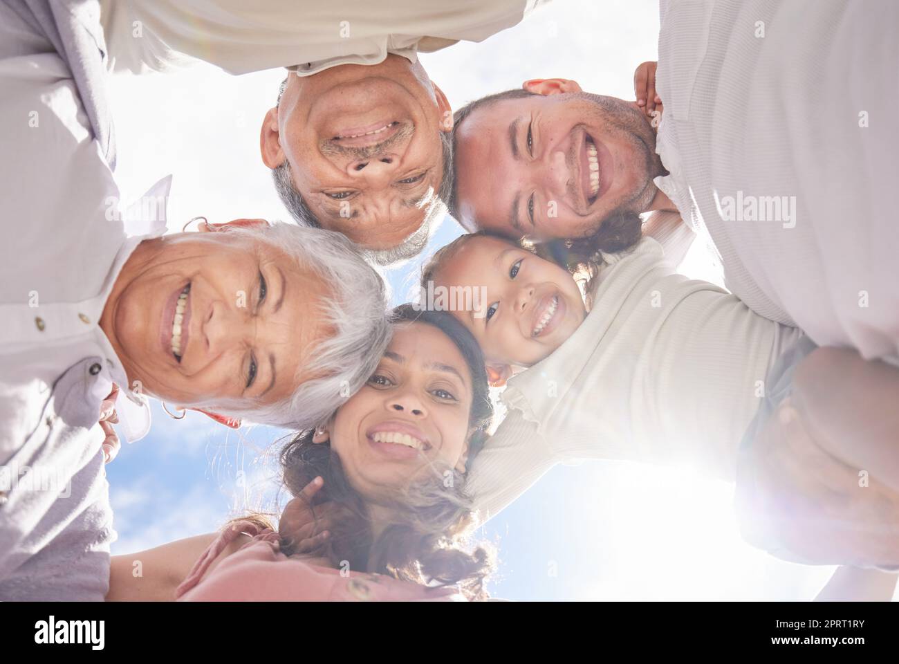 Family love, summer portrait and sky in nature, happy kid with parents and grandparents with smile in spring. Face of child with motivation and support from mother, father and senior people Stock Photo