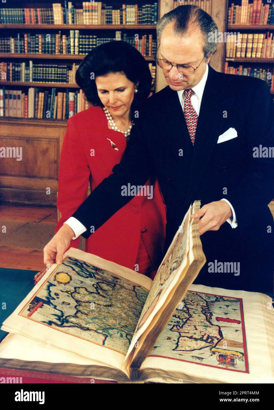 SWEDISH ROYAL COUPLE  in the Bernadotte library in the royal palace where they look in one of all the historical map books Stock Photo