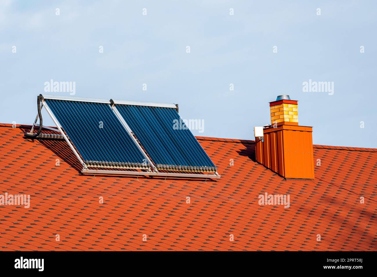 Solar water heater installed on a red roof. Renewable Energy Home Stock ...