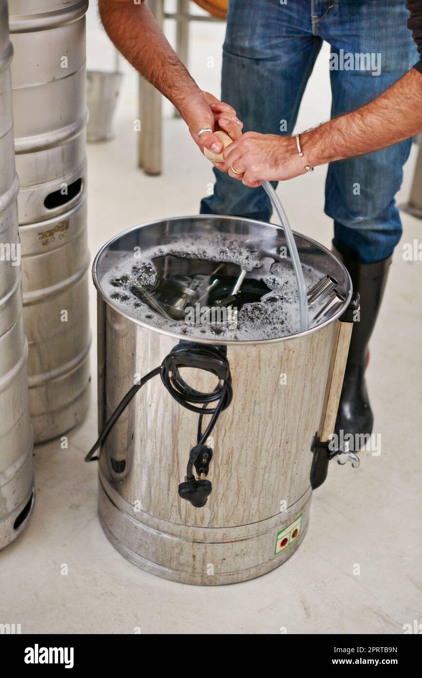 Cleanliness is essential in a brewery. a man working in a microbrewery. Stock Photo