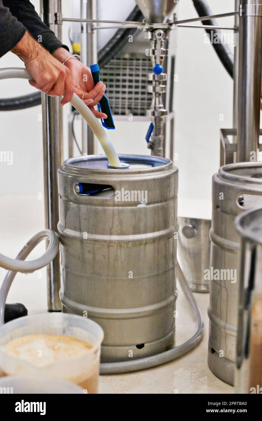 Pouring a perfect brew. a man filling kegs at a brewery Stock Photo Alamy