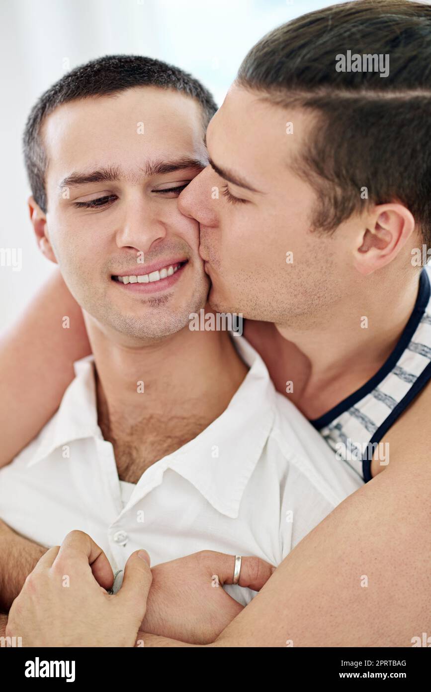 Isnt love grand. a young gay couple relaxing on a sofa at home. Stock Photo