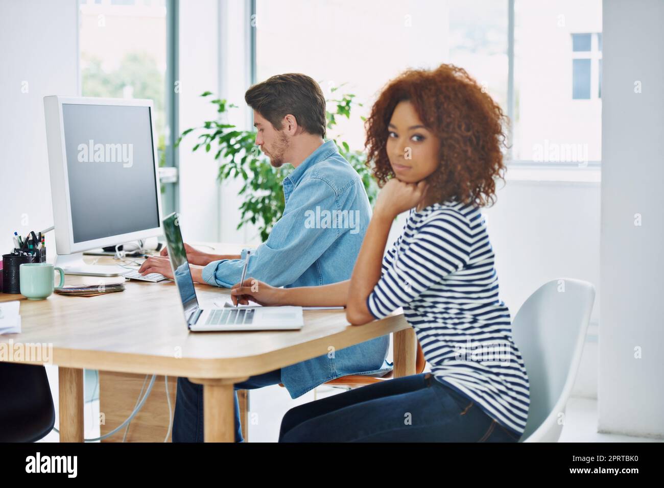 Teamwork makes the dream work. two coworkers working together at their desks. Stock Photo