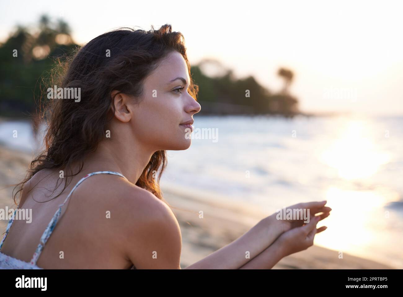 Enjoying the quietness of the beach. a beautiful young woman on the beach. Stock Photo