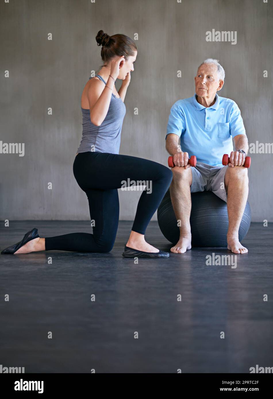 Helping my patients recover is my only priority. a a physical therapist working with a senior man. Stock Photo