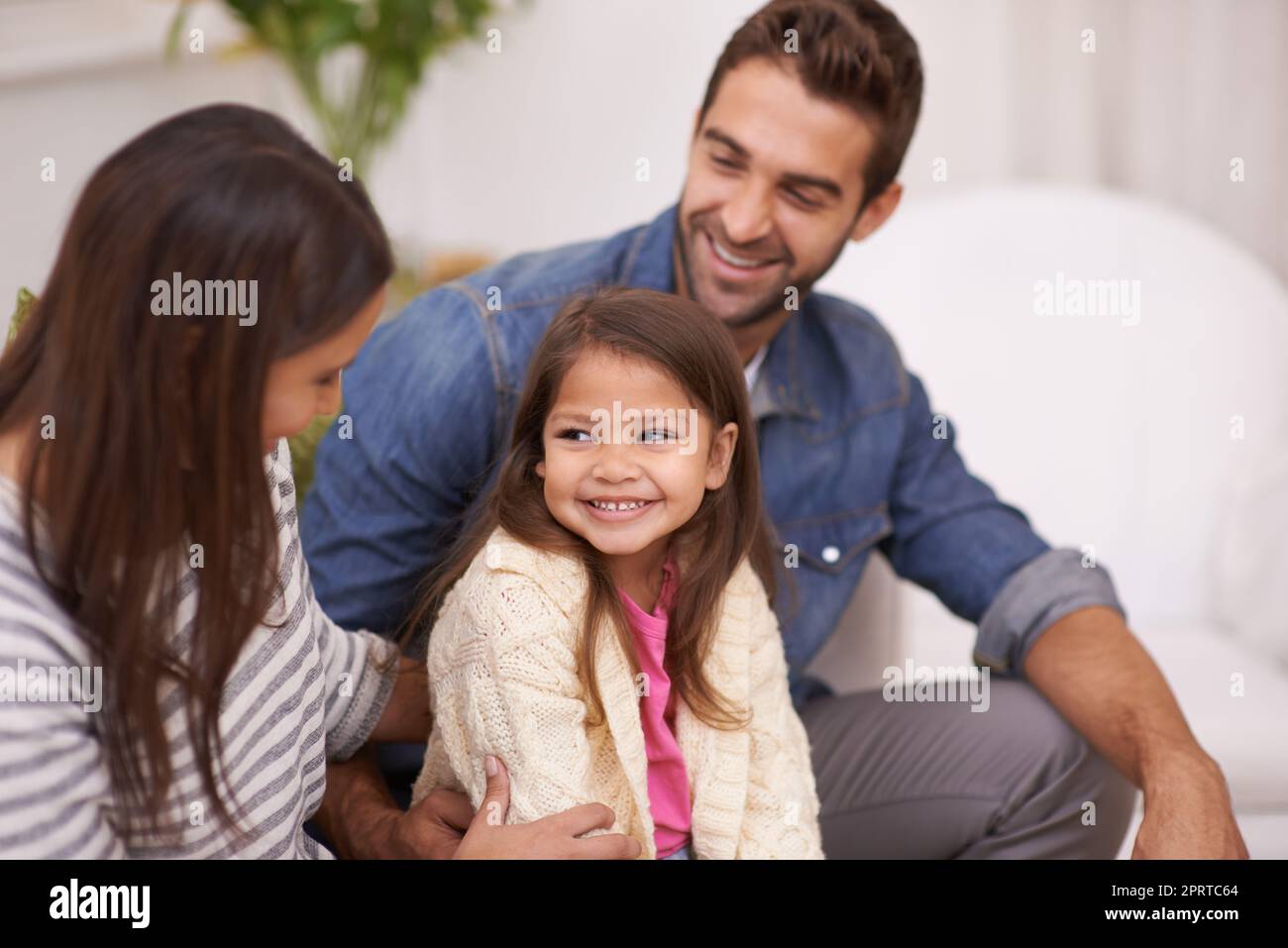 Relaxing with the ones you love. a happy young family sitting together at home. Stock Photo