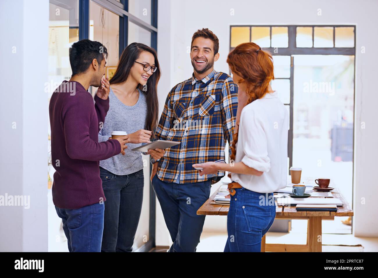 Socializing with the team. four young designers having a discussion in their office. Stock Photo