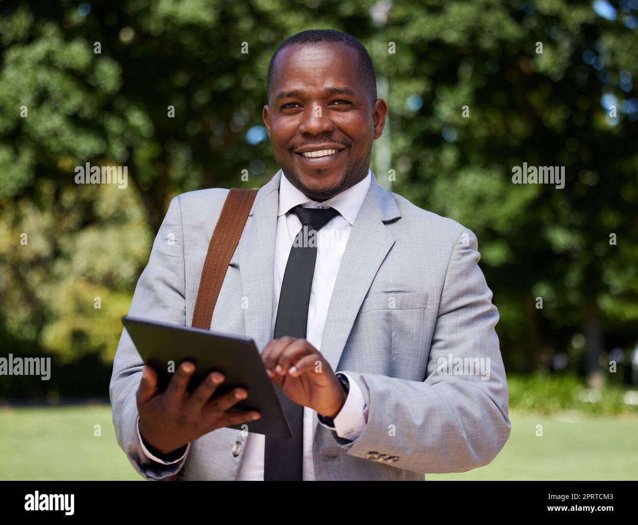 Black man, tablet schedule or business travel in park, nature garden or community environment in morning to work. Portrait, smile or happy worker or interview employee with 5g communication technoloy Stock Photo