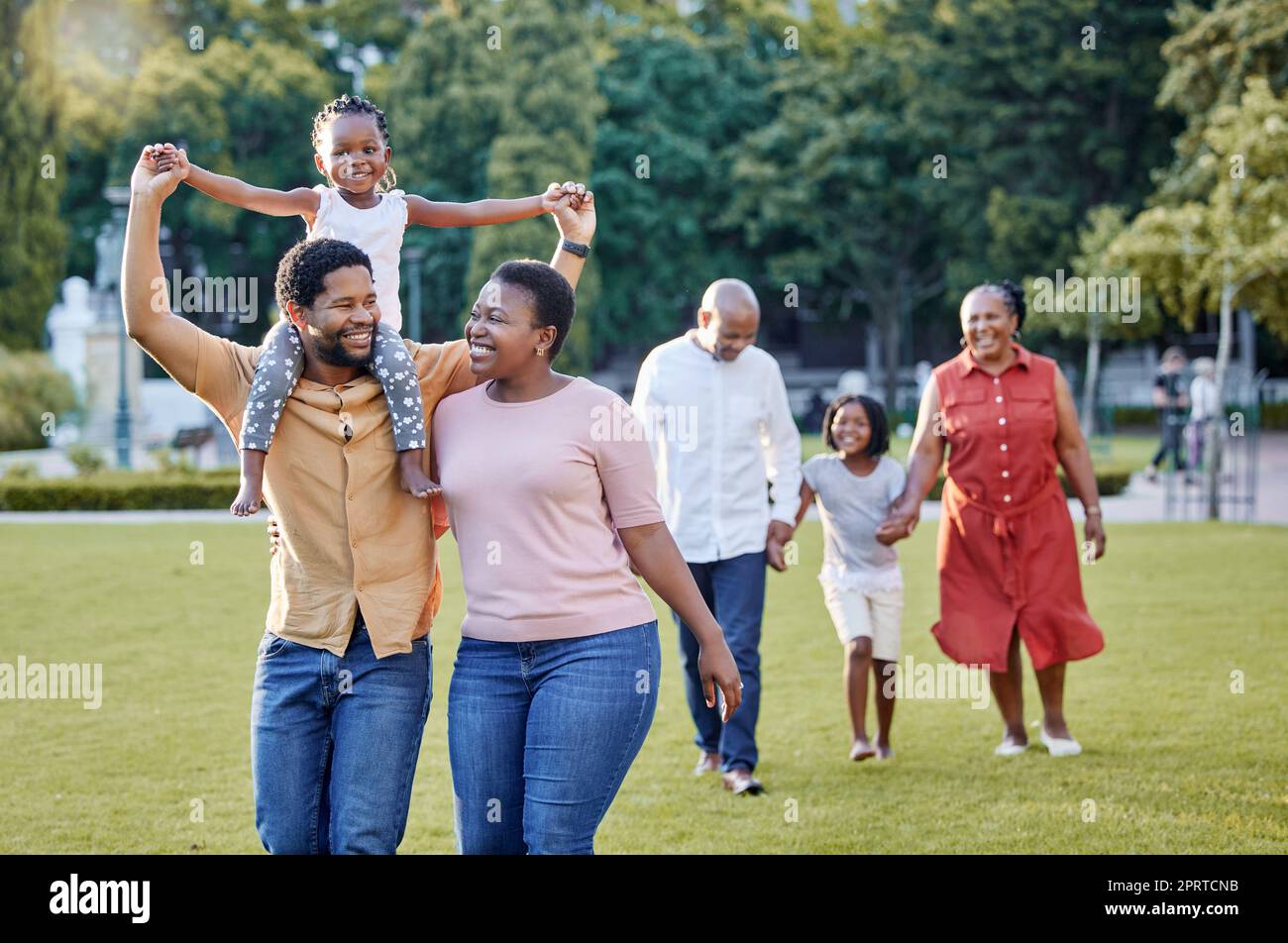 Generation of happy family walking in park, garden and summer nature outdoors to relax, bonding during quality time. Black people with grandparents, parents and children in love, care and support Stock Photo
