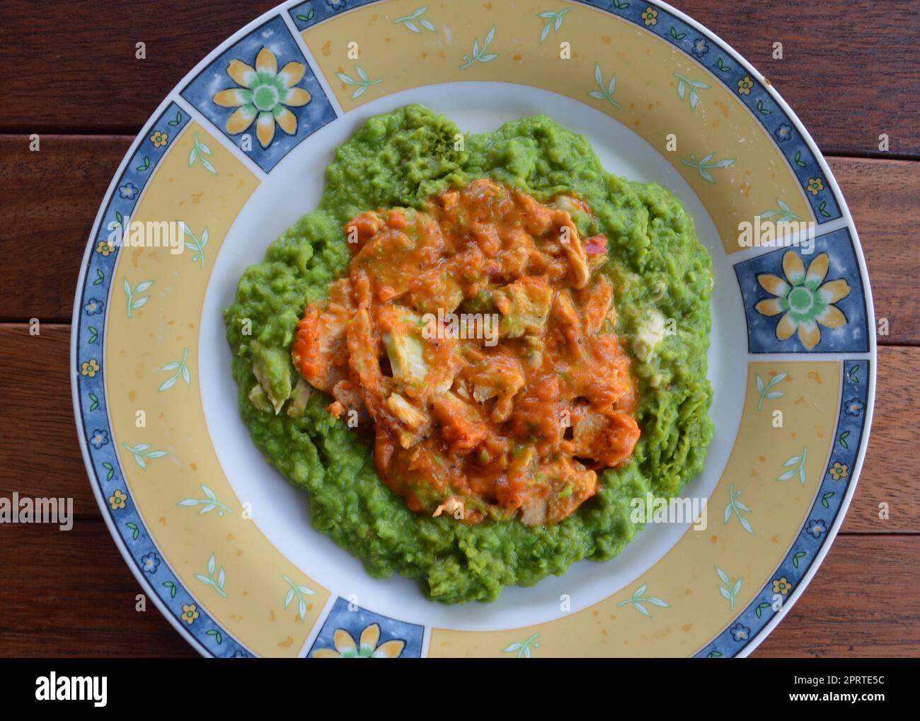 Lemon and pepper chicken with mashed peas Stock Photo