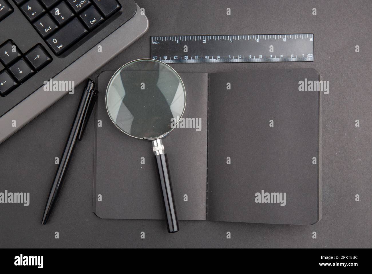 top view black notebook pen keyboard lupa ruler on dark background ...
