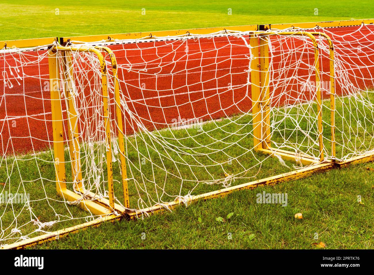 Small football goals lined up next a running track Stock Photo