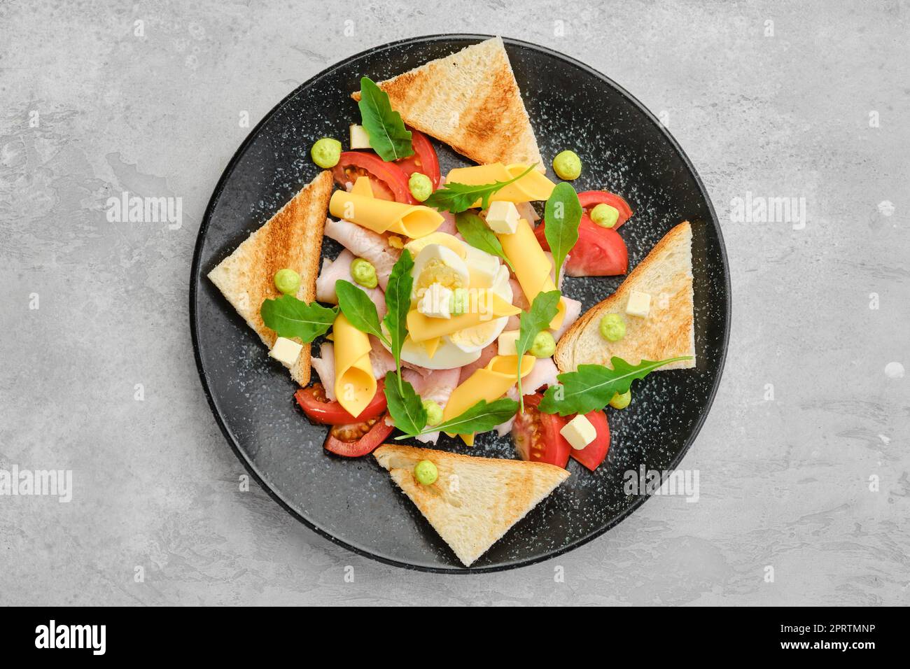 Top view of pieces of toast, ham, boiled egg, cheddar and tomato Stock