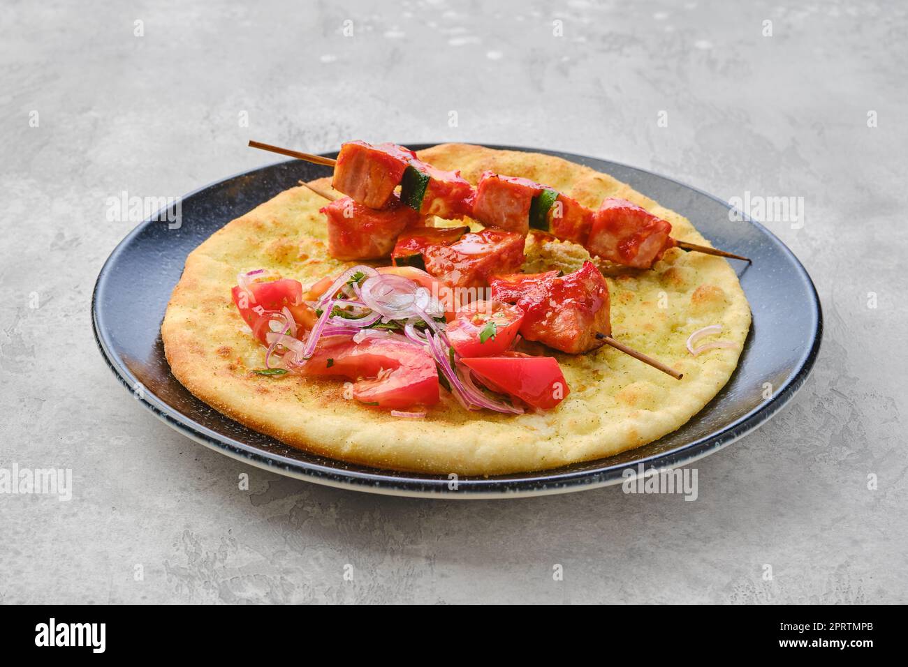 Shashlik served on tortilla with tomato and onion Stock Photo