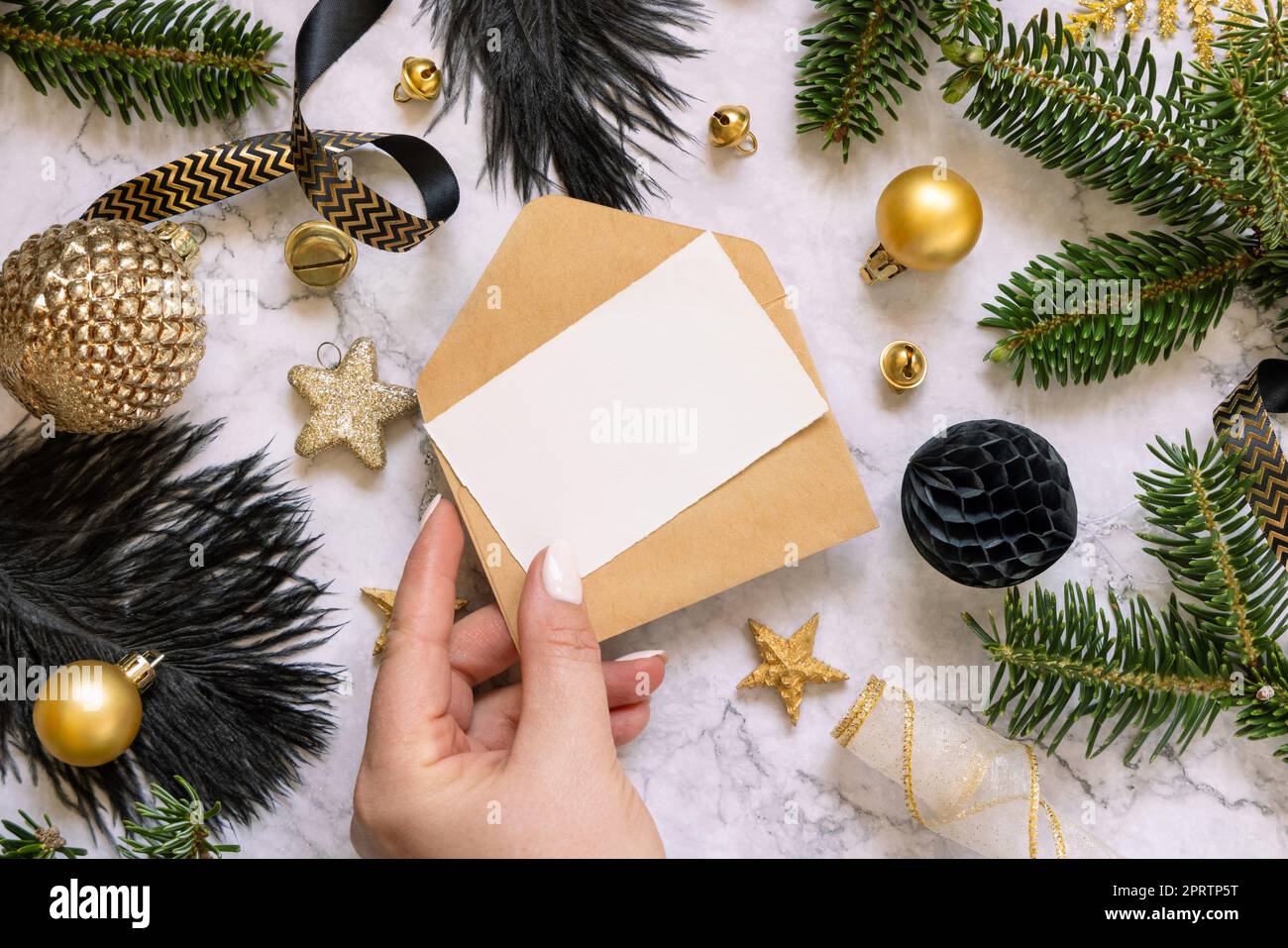 Hand holding Card and envelope, black and golden Christmas decorations ...