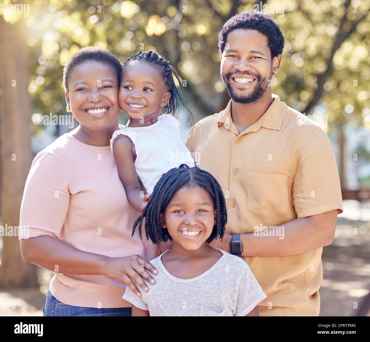 Portrait of a happy black family in nature in a garden for summer picnic while on holiday. Smile, love and african mother and father with their girl children in outdoor park on a countryside vacation Stock Photo