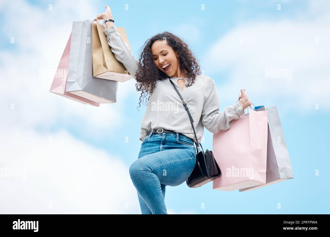 City shopping, retail sale and woman with fashion deal, excited about luxury discount and happy about designer market on blue sky in Paris. Rich, wealth and young girl with bag and smile in summer Stock Photo