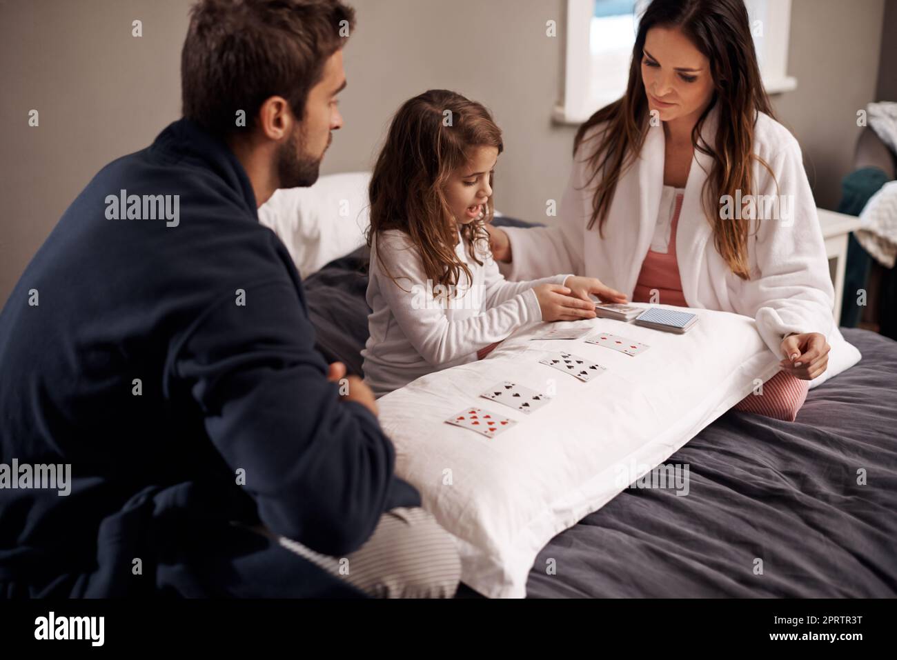 House of cards. a young family playing cards together at home. Stock Photo
