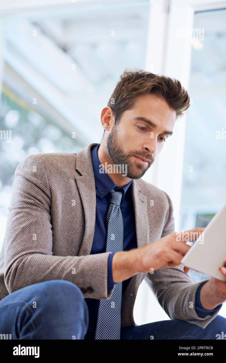 Checking his digital diary. a businessman using his digital tablet. Stock Photo