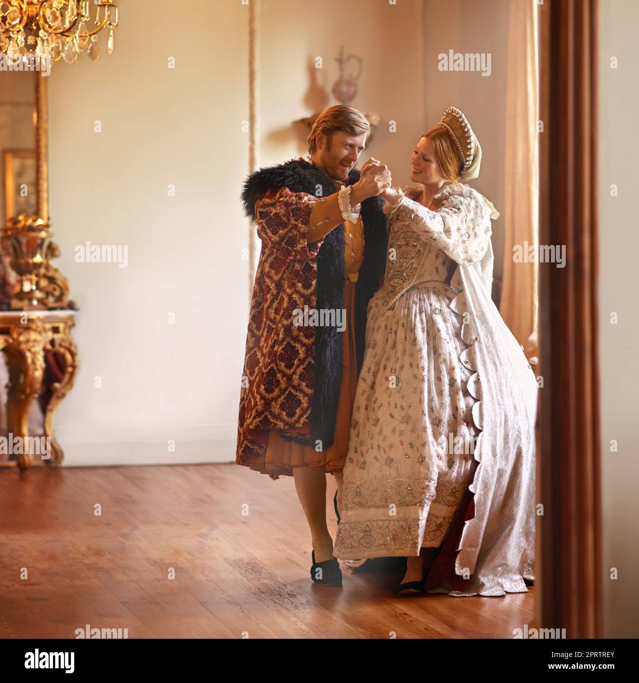 A waltz among royalty. A king and queen dancing together in their palace. Stock Photo