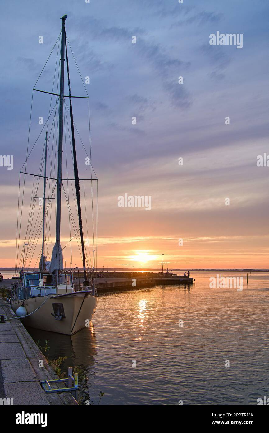 Sailing ship in the harbor of lake Vaettern at sunset. Lighthouse in ...