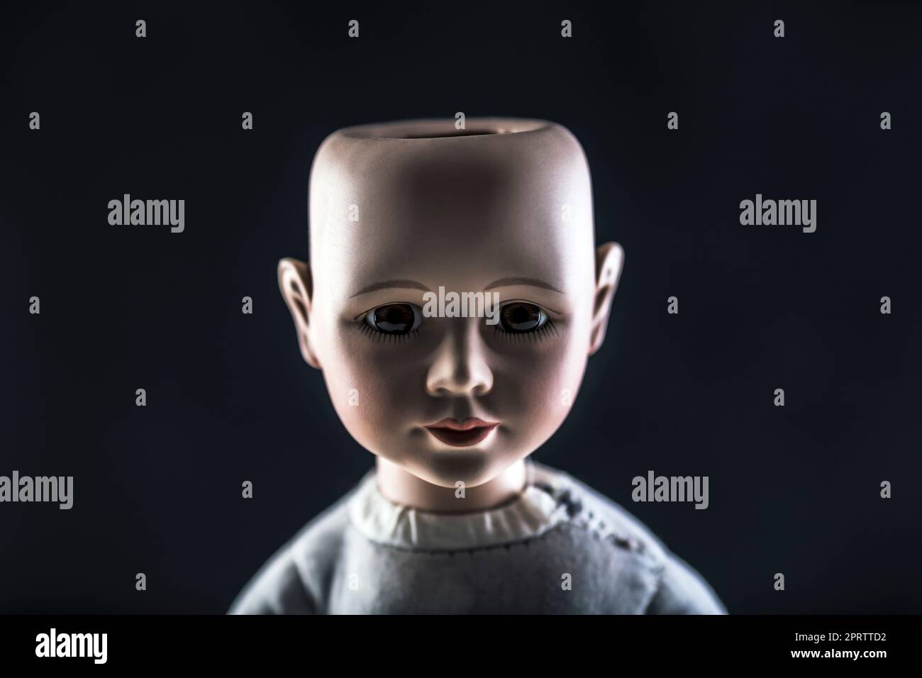 Creepy doll face on dark background Stock Photo