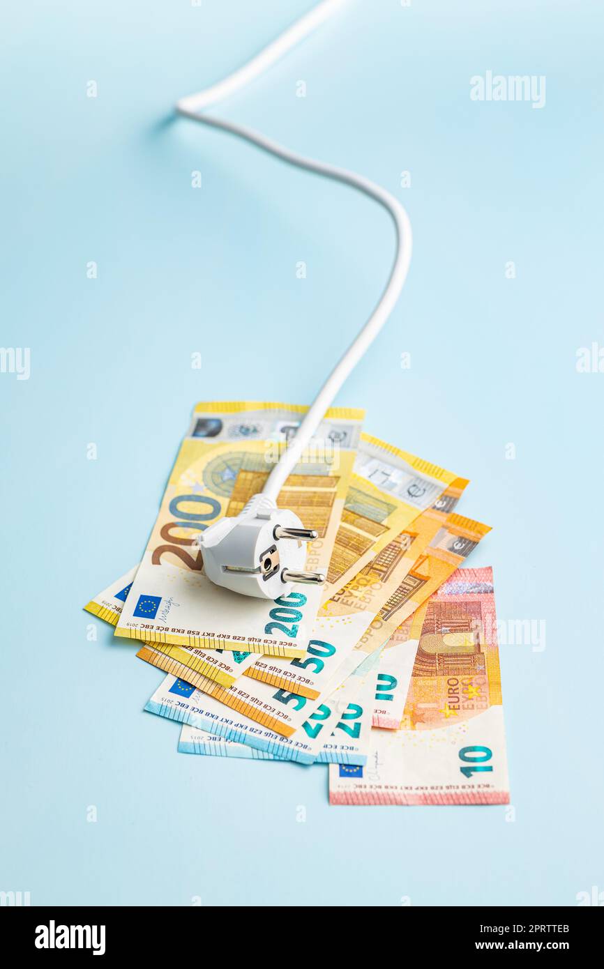 Electric plug and euro money on blue background. Concept of increasing electric prices. Stock Photo