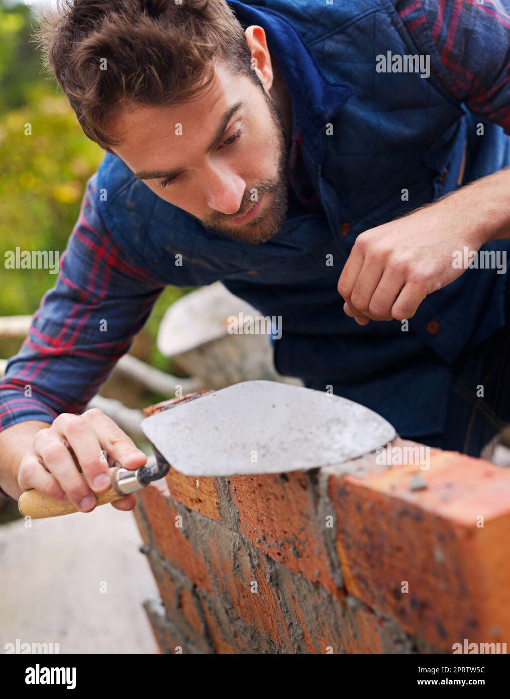 The perfect amount of mortar. a master bricklayer at work. Stock Photo