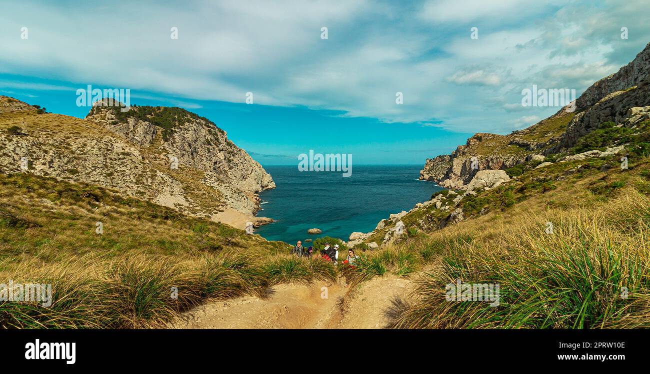 Crystal clear waters of a tranquil cove, surrounded by rocky cliffs and lush vegetation. Perfect for travel and nature themes, with emphasis on the me Stock Photo