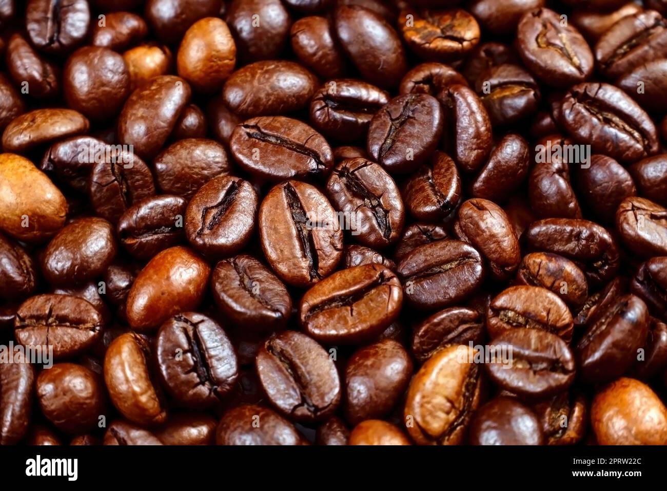 Dark brown roasted coffee beans as a texture close up Stock Photo - Alamy
