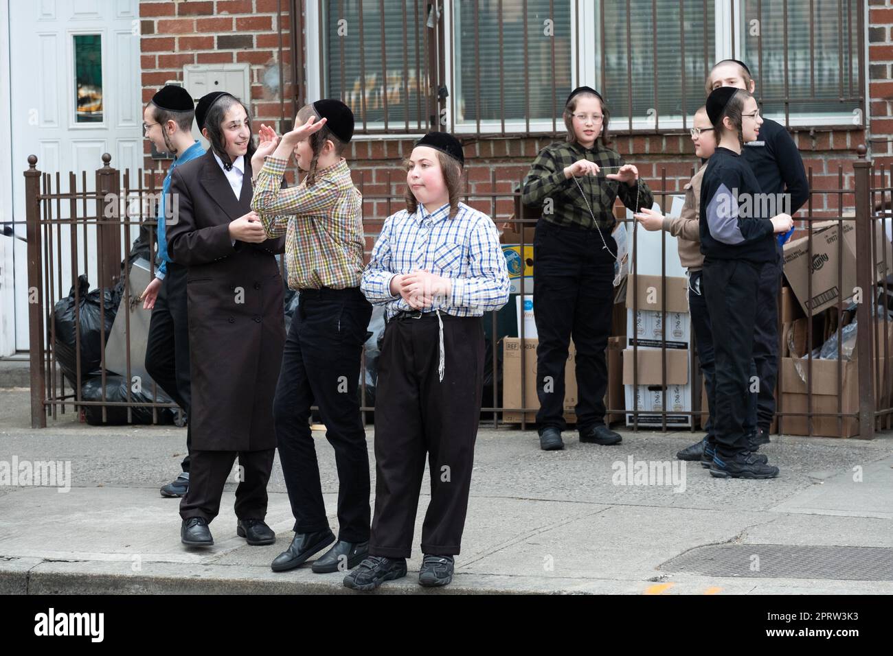 Yeshiva students hang out alone & in groups during recess. Outtside a school in Brooklyn, New York. Stock Photo
