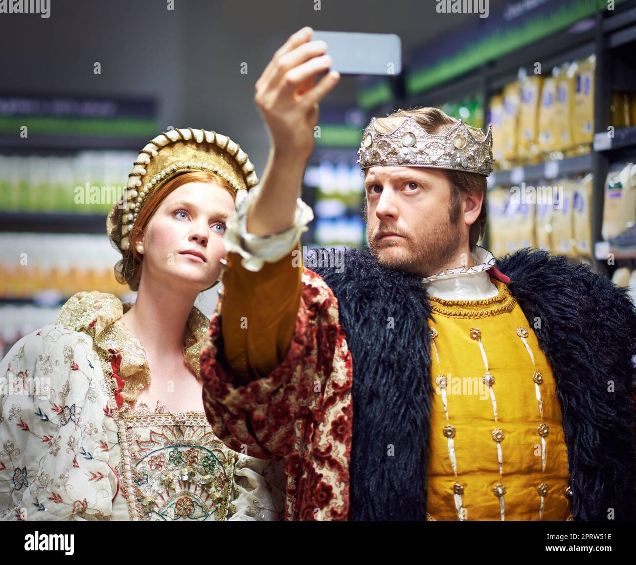 Not too royal to shop. A king and queen taking a selfie in their local supermarket. Stock Photo