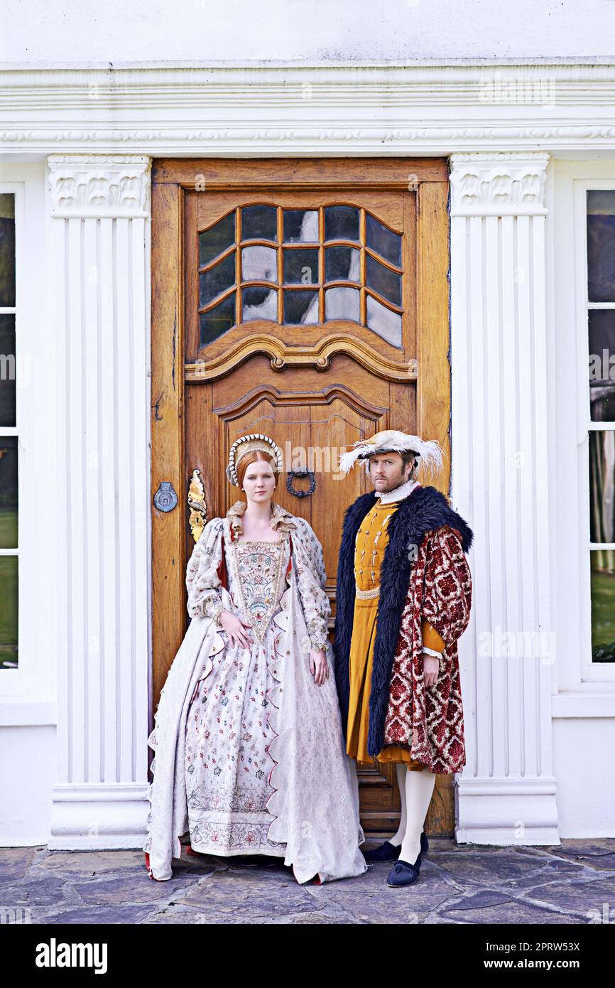 Our humble abode is yours. a royal couple standing in front of their home. Stock Photo