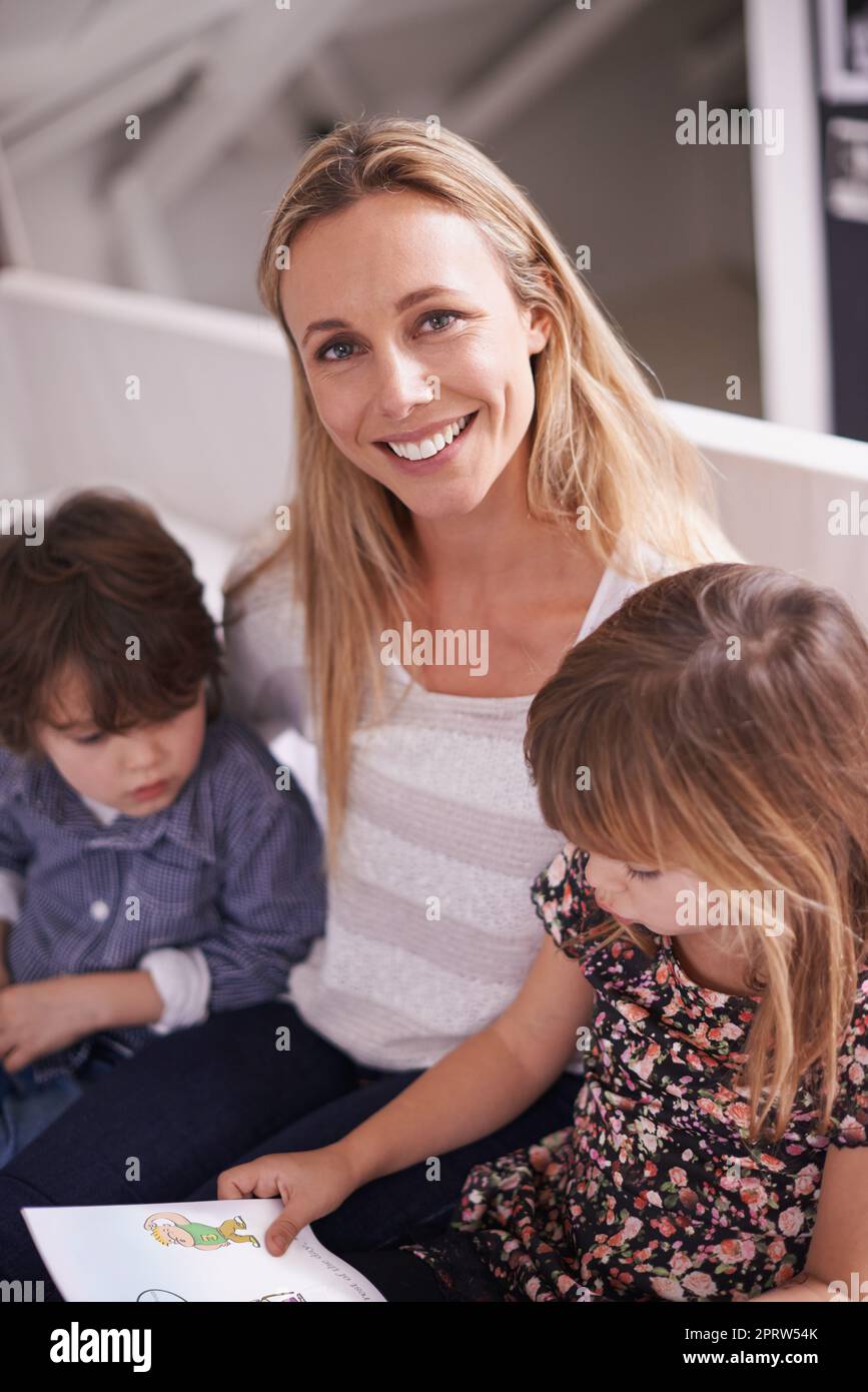 They love story time. a mother reading with her children at home. Stock Photo