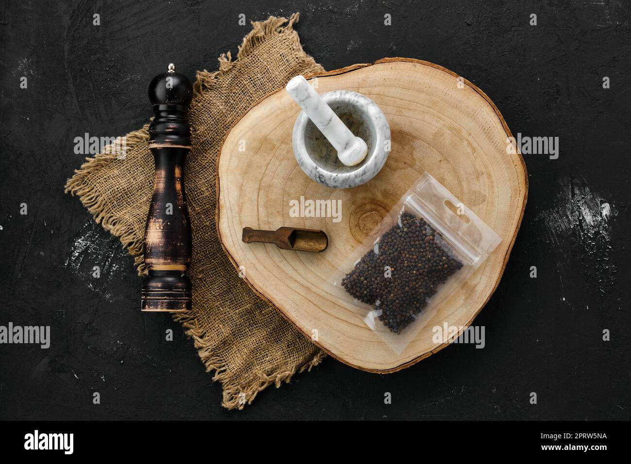 Wooden cross section with peppercorn in plastic package and mortar and ...