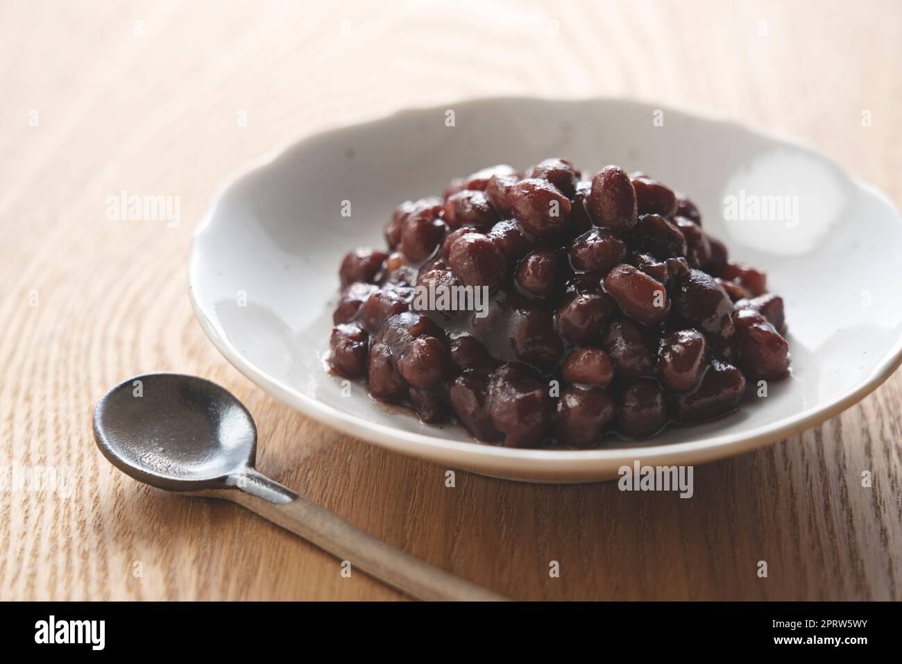 Boiled azuki beans placed against a wooden background. Stock Photo