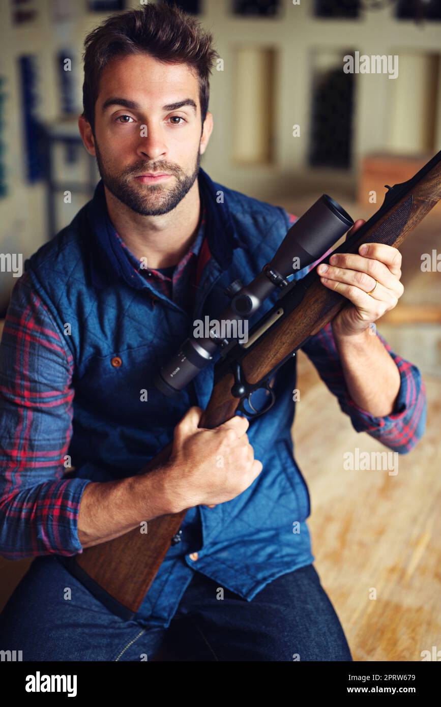 Its hunting season. Portrait of a hunter posing with his rifle. Stock Photo