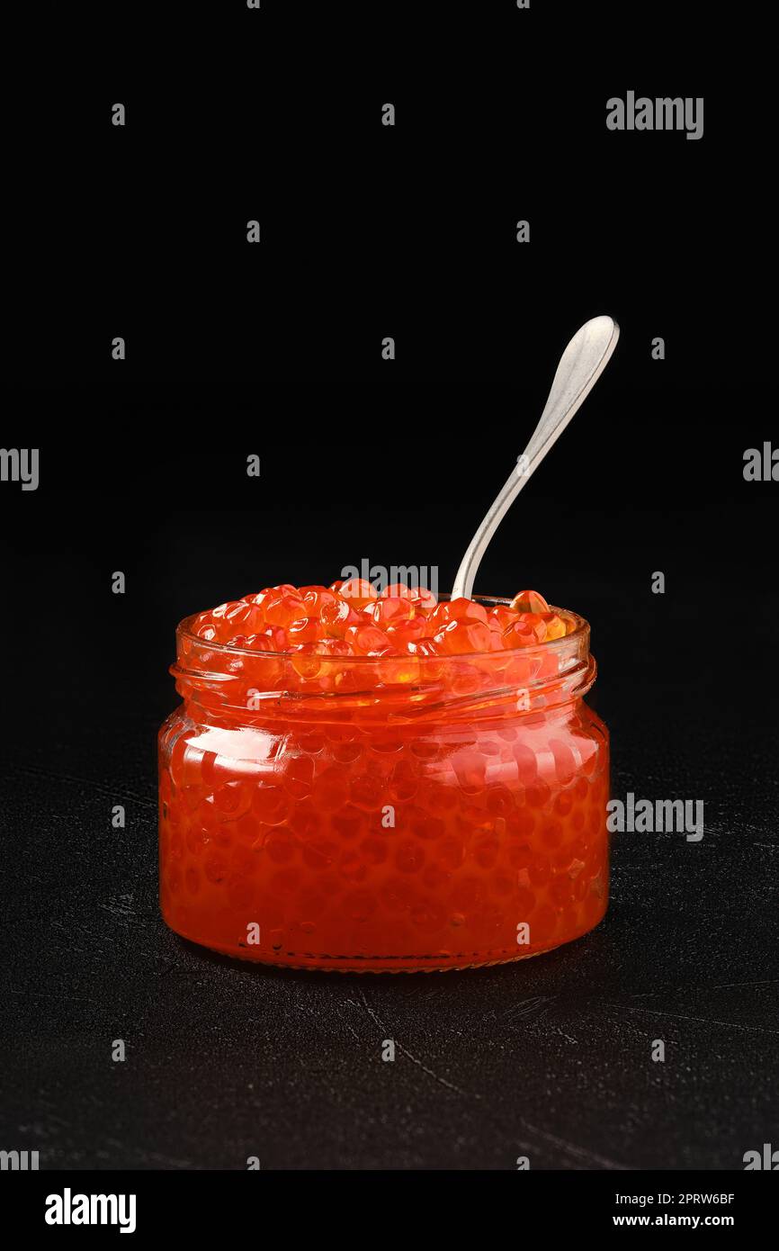 Open jar with red caviar and a spoon in it Stock Photo Alamy