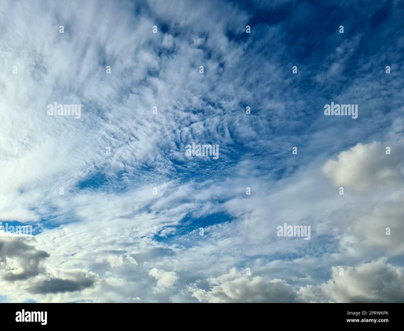 Beautiful fluffy white cloud formations in a deep blue summer sky Stock Photo