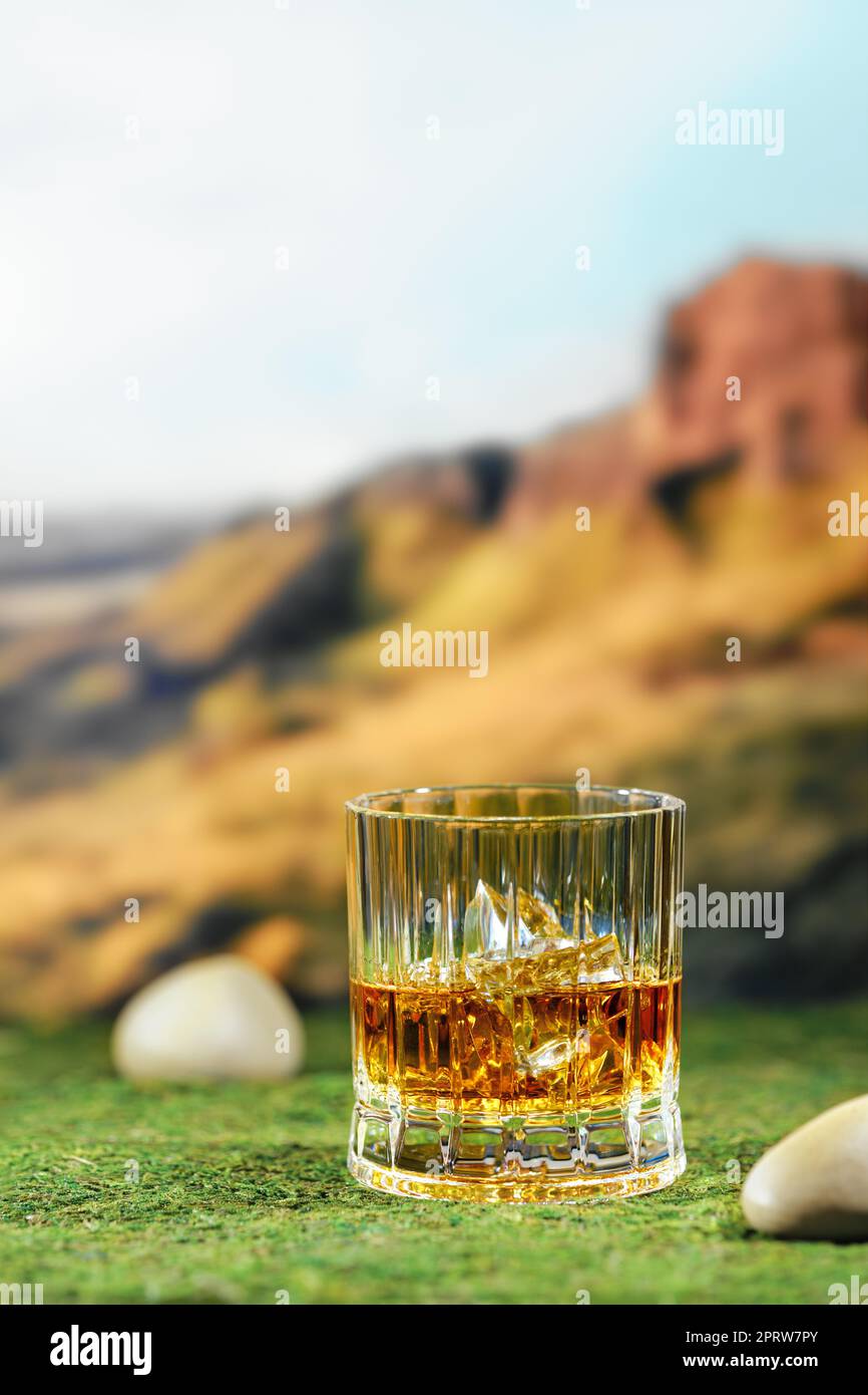 Glass of peat whiskey on green moss Stock Photo Alamy