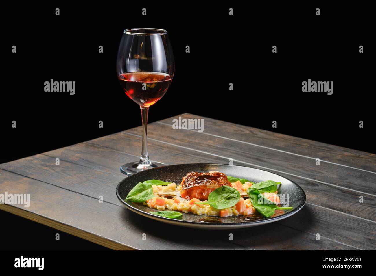 Roasted salmon fillet with bulgur with glass of rose wine Stock Photo