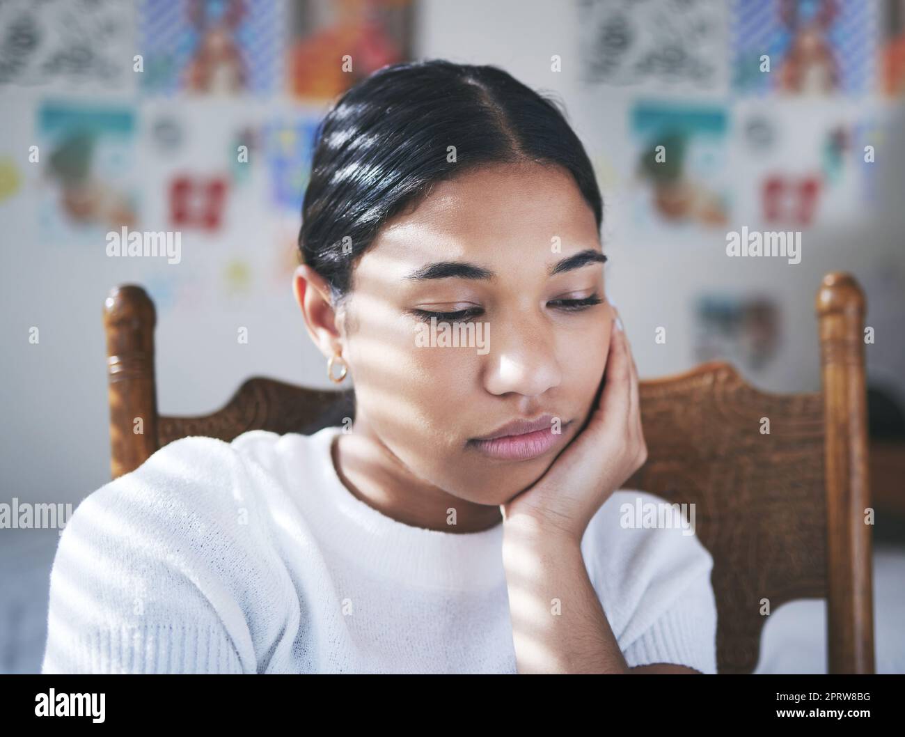 Depression, anxiety and stress by woman thinking and looking sad, sitting and lonely in her bedroom. Young female suffering with mental health problem after a breakup, bad news or suicide thoughts Stock Photo