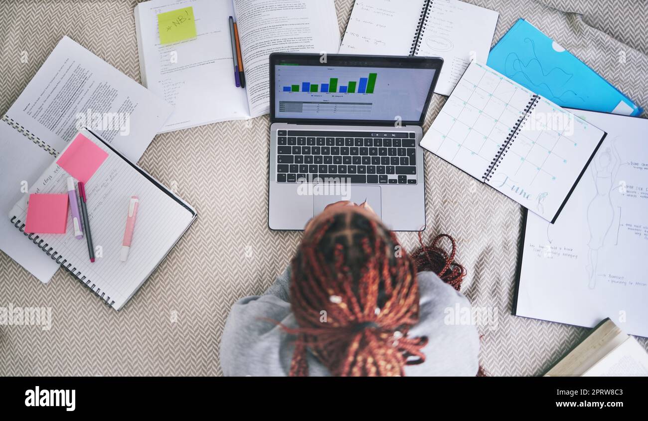 College education and study laptop on bed with school books and sticky