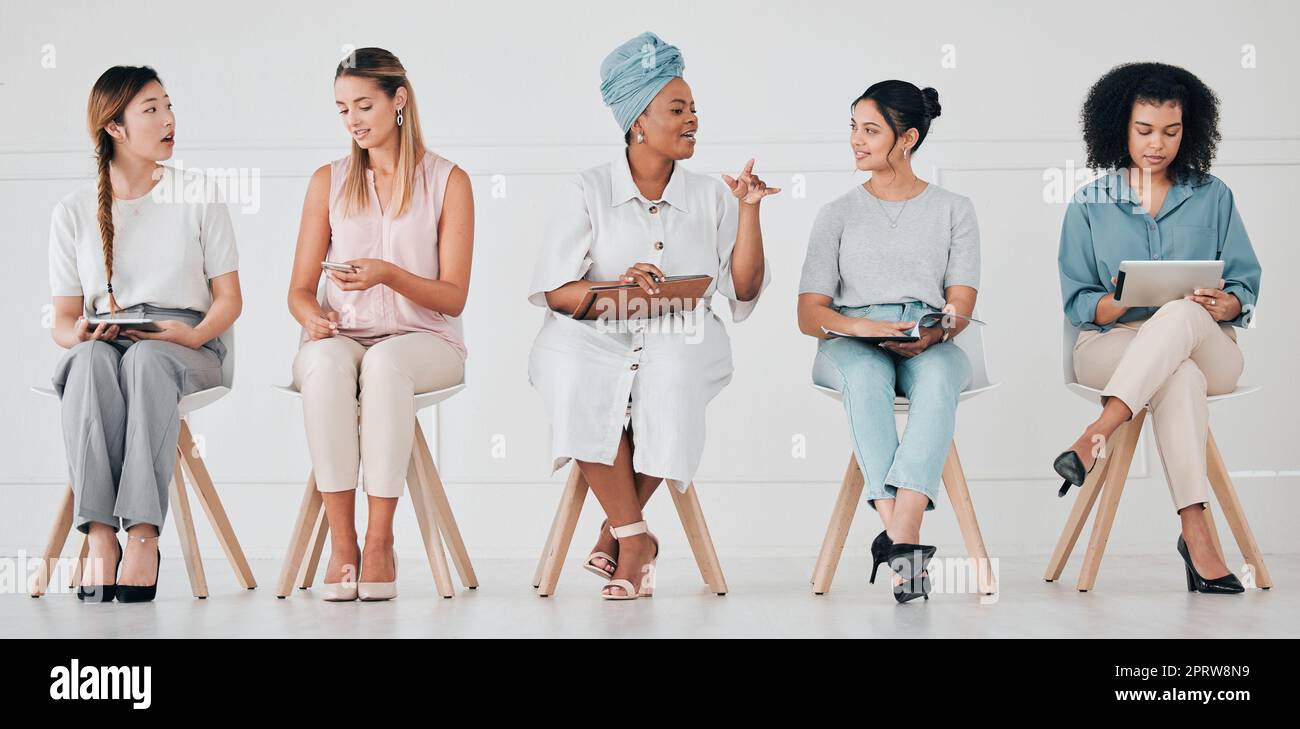 Hiring, recruitment and interview of business women waiting for company management hire team. Diversity of talking and work communication of group using technology in a office to wait for a meeting Stock Photo