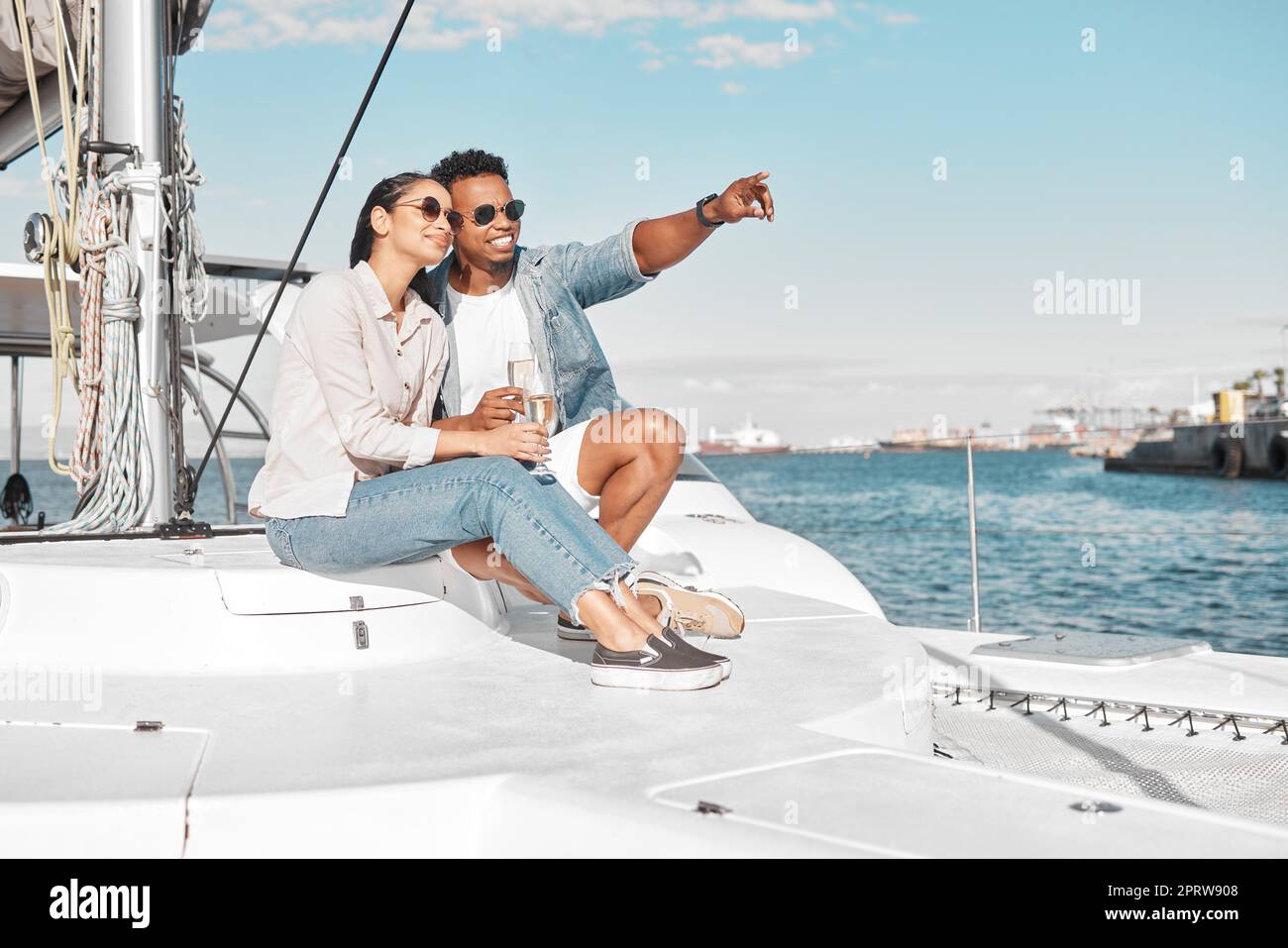 Couple, love and yacht with a man and woman out at sea or on the ocean for romance and a luxury date or cruise. Happy, trust and care with a young male and female on a boat in the water together Stock Photo