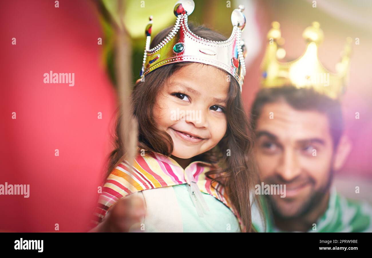 Hands off, theres only place for one queen here. A cute little girl dressed up as a princess while playing at home with her dad. Stock Photo