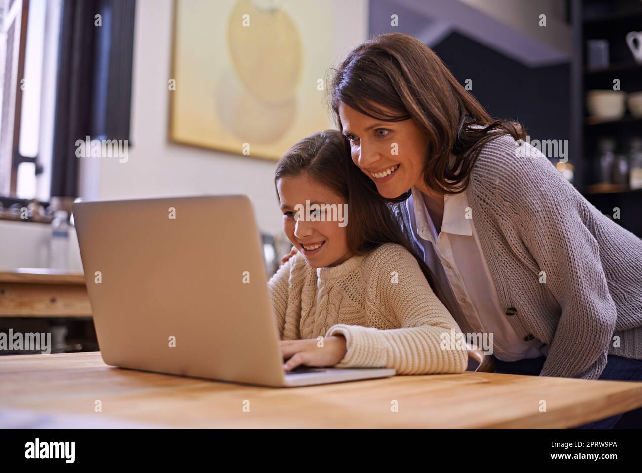 So many interesting things. a young girl studying with her mother nearby to help. Stock Photo