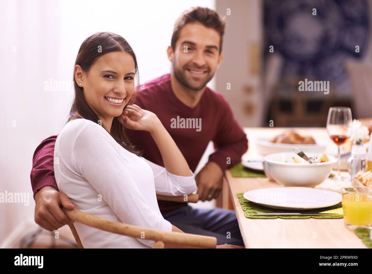 Food brings everyone together. A happy couple enjoying a family meal around the table. Stock Photo