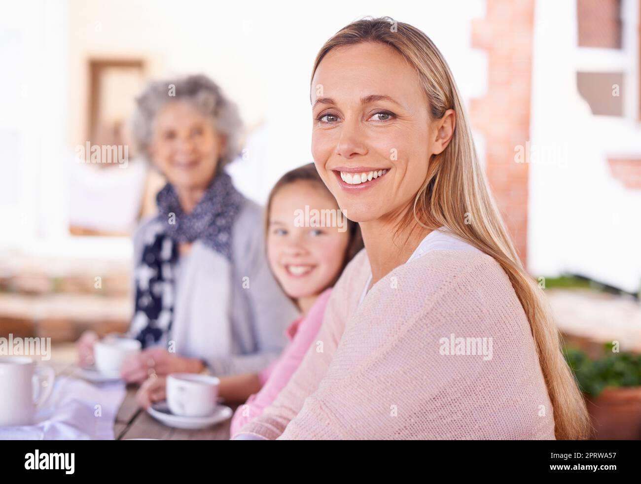 These girls love their tea. three generations of the woman of the women of a family having tea outside. Stock Photo